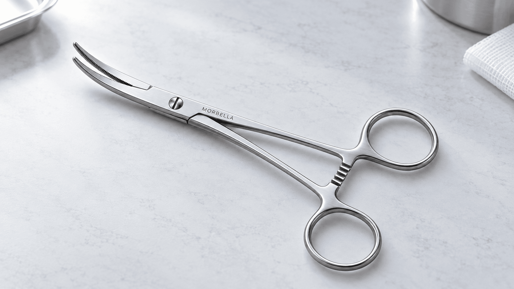 Morbella curved hemostatic forceps with ratchet on a marble surface — cover for “Forceps, hemostats and needle holders: telling the patterns apart”